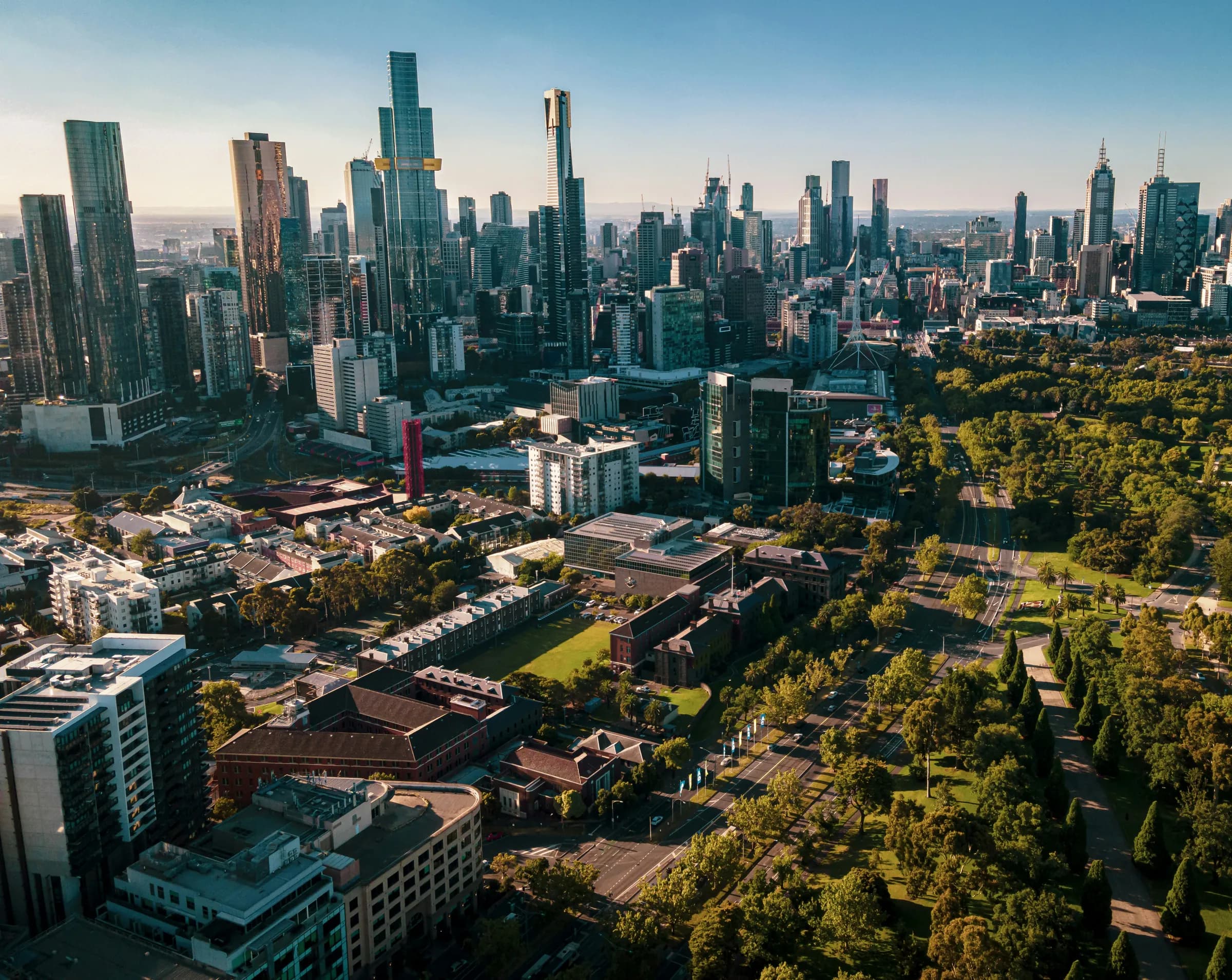 Melbourne's skyline from above St Kilda Road, the tree-lined boulevard and parkland running right beside the traffic